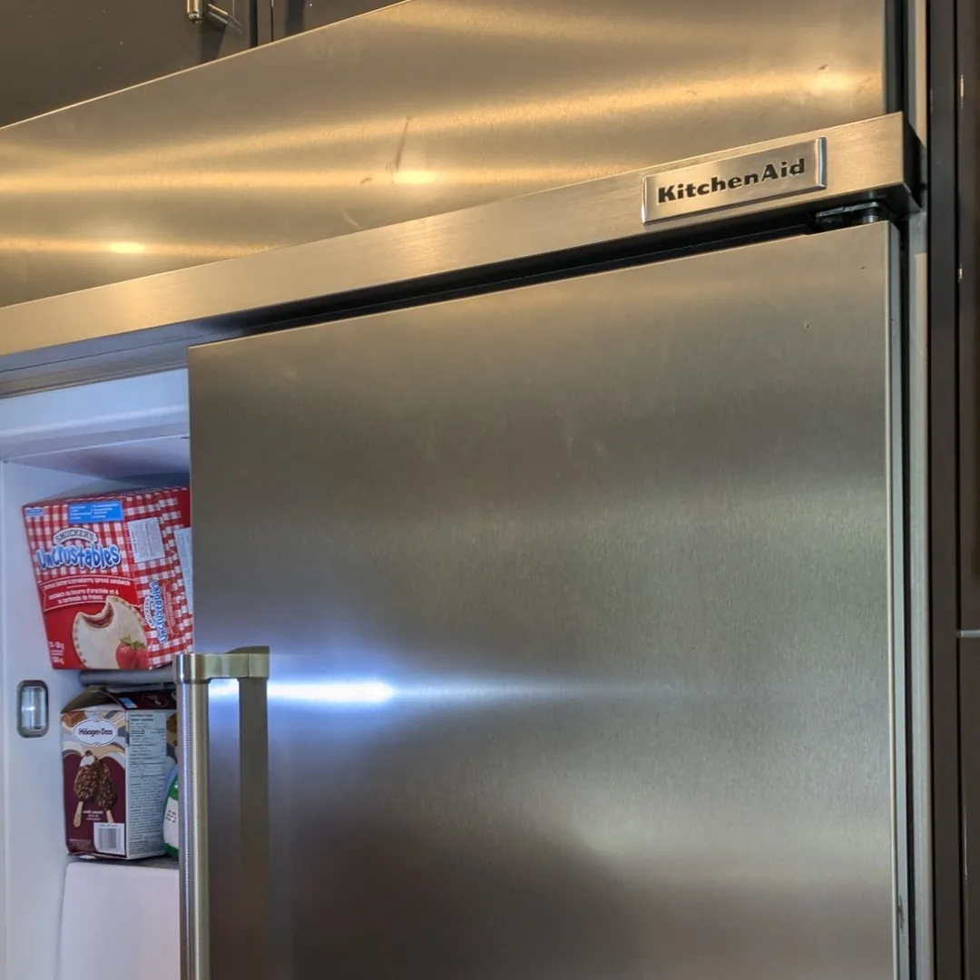 Technician servicing a KitchenAid refrigerator